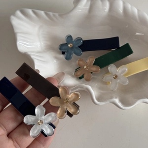 Dettaglio di fermagli per capelli a fiore con strass dorati in vari colori moderni