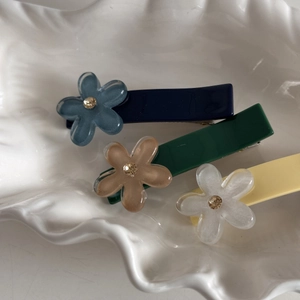 Dettaglio di fermagli per capelli a fiore in resina con centri di cristallo