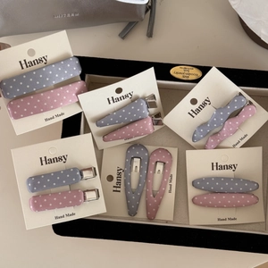 Set dettagliato di fermagli in tessuto a pois rosa e blu su scheda display