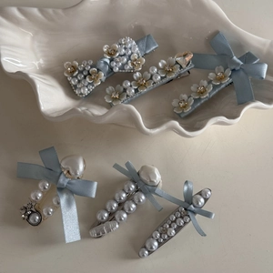 Elegant 6-piece hair clip set with blue silk bows, faux pearls, and rhinestones in shell tray
