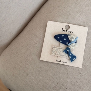 Détail de nœuds bleus à pois faits main et barrettes en dentelle sur carte