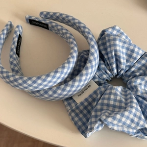 Detail von blau-weiß karierten Schwamm-Stirnbändern und Haargummi mit Handmade-Label