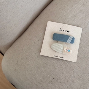 Détails des barrettes en denim bleu avec dentelle et carreaux sur carte lapin