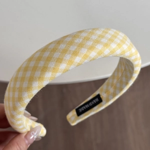 Detail eines handgefertigten gelben Gingham-Haarband mit hochwertiger Stoffstruktur