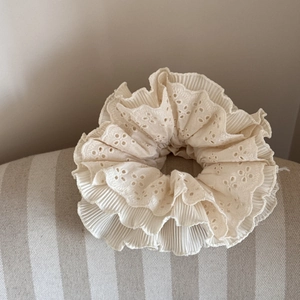Detailed close-up showing fine hollow lace embroidery and layers of off-white scrunchie