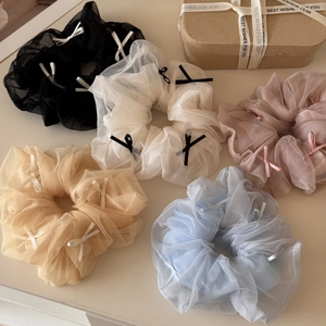 Close-up of five mesh hair scrunchies with mini bows in pastel Morandi colors