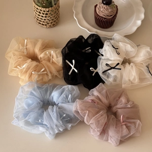 Detailed macro view of five tulle bow scrunchies in beige, black, white, blue and pink
