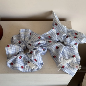 Sweet light blue gingham hair scrunchies with red strawberry patterns and white lace edges
