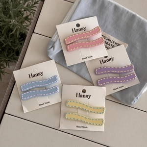 Detail showing wavy pastel hair clips set with contrast stitching on white display card