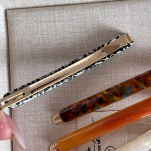 Vista macro dettagliata dei fermagli per capelli in acetato con stampa leopardata e chiusura oro