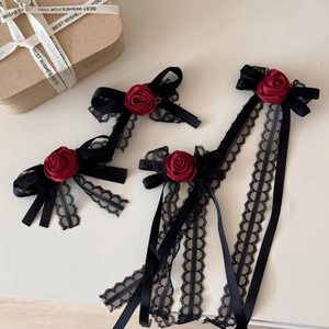 Detail view of gothic red rose hair clips with black lace and long ribbon tassels