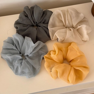 Set of four plaid chiffon scrunchies in gray, beige, blue and yellow on white background
