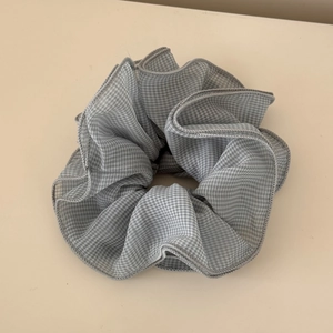 Close-up of grey gingham plaid oversized scrunchie with detailed pleated edges