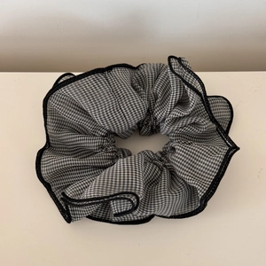 Close-up detail of black and white plaid chiffon scrunchie with durable stitched edges