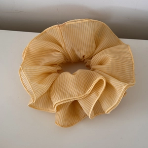 Detail showing the yellow gingham texture and refined ruffled edges of the chiffon scrunchie