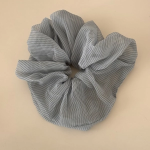 Detail of grey and white gingham organza fabric with pleated texture on oversized scrunchie