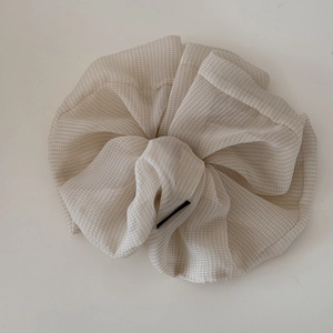 Detail of premium beige gingham chiffon scrunchie showing pleated fabric texture and pattern