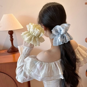 Elegant floral lace scrunchies in beige and blue displayed in a warm home setting