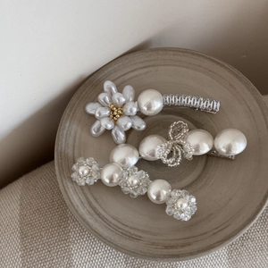 Barrettes à cheveux fleurs en perles baroques vintage sur un plat en céramique chic