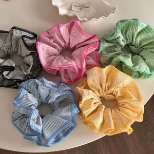 Macro shot of colorful striped fabric scrunchies with premium stitched edge detailing