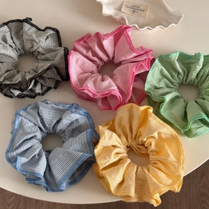 Set of five colorful striped scrunchies with wavy edges in pink blue and yellow