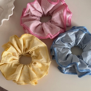 Three colorful striped oversized hair scrunchies in pink, yellow, and blue pastel tones