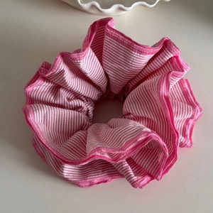 Detail of pink and white striped scrunchie showing fabric texture and pleats