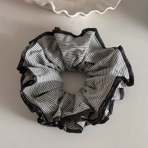 Detailed macro view of large black and white striped hair scrunchie with stitched edges