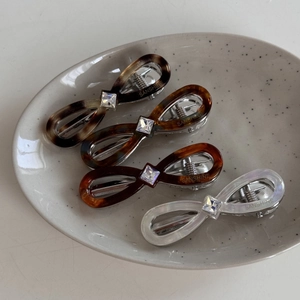 Detail of four acetate hair clips with square crystal inlay and silver metal springs