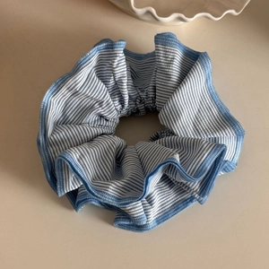 Detailed view of blue and white striped scrunchie with soft knitted cotton texture