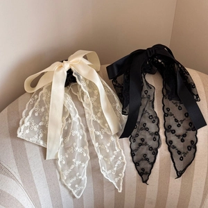 Detail of French lace bow hair clips in black and cream white with elegant embroidery