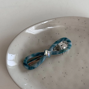 Detail of blue-green marble acetate hair clip with a square crystal and silver spring clip