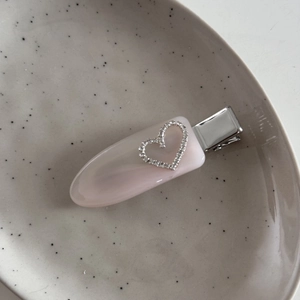 Detail der rosa Acetat-Haarklammer mit glitzerndem Strassherz auf Keramikschale