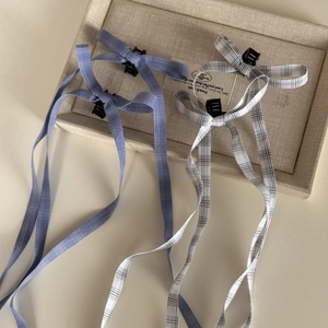 Detail shot of ballet style plaid bow hair clips with long ribbons on a display tray