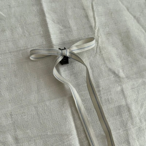 Detail of ballet style ribbon bow hair claw with light blue stripes and long streamers