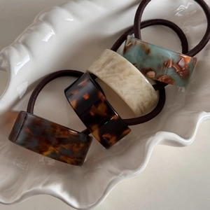 Elegant 4-piece acetate geometric hair ties set with marbled textures in a shell tray