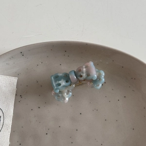 Macro view of blue and pink gradient acetic acid bow hair clip with hollow details