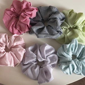 Detailed flat lay of six colorful gingham scrunchies in pastel tones with soft cotton texture