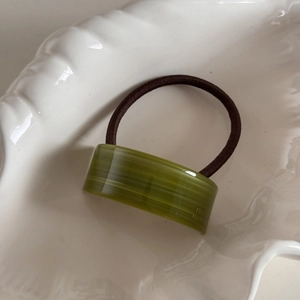 Detail of green acetate rectangle hair tie with France Handmade gold foil stamping