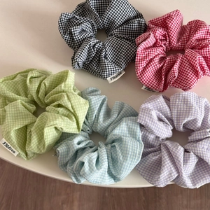 Detail of five-color checkered cotton scrunchies with elegant pleats and woven labels