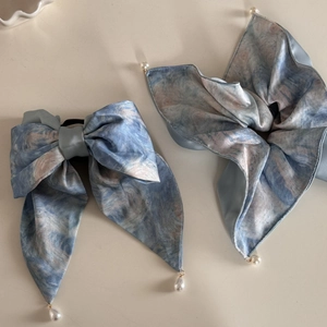 Détail de barrettes à nœud style peinture à l'huile avec perles élégantes et texture soie