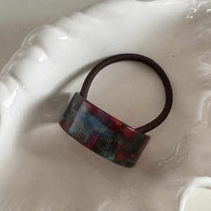 Detail view of handmade marble pattern acetate bead on a high elastic ponytail hair tie