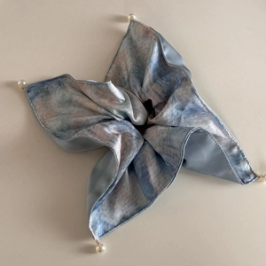 Détail d'une pince à cheveux papillon avec motif peinture à l'huile et pendentifs perles