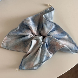 Détail d'un chouchou en soie avec motif de peinture à l'huile de Monet et perle pendante