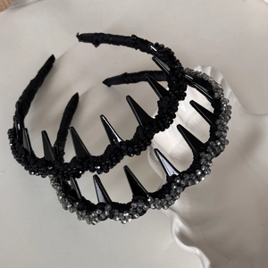 Serre-têtes ondulés élégants ornés de strass, rivets et perles dans un plateau blanc