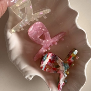 Trois pinces à cheveux en acétate blanc nacré, marbre rose et motifs floraux