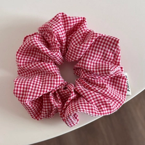 Detailed view of red and white gingham fabric texture on a large oversized scrunchie hair tie