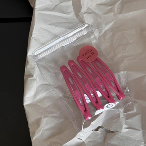 Detail of 4-piece matte pink waterdrop hair clips in clear packaging with a round sticker