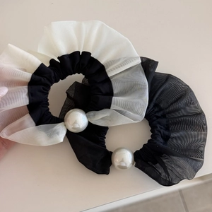 Detail of ruffle mesh hair scrunchies with faux pearl accents in black and white