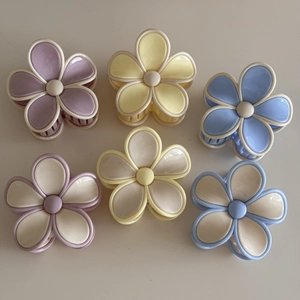 Close-up of six colorful flower hair claws in pastel purple, yellow, and blue resin